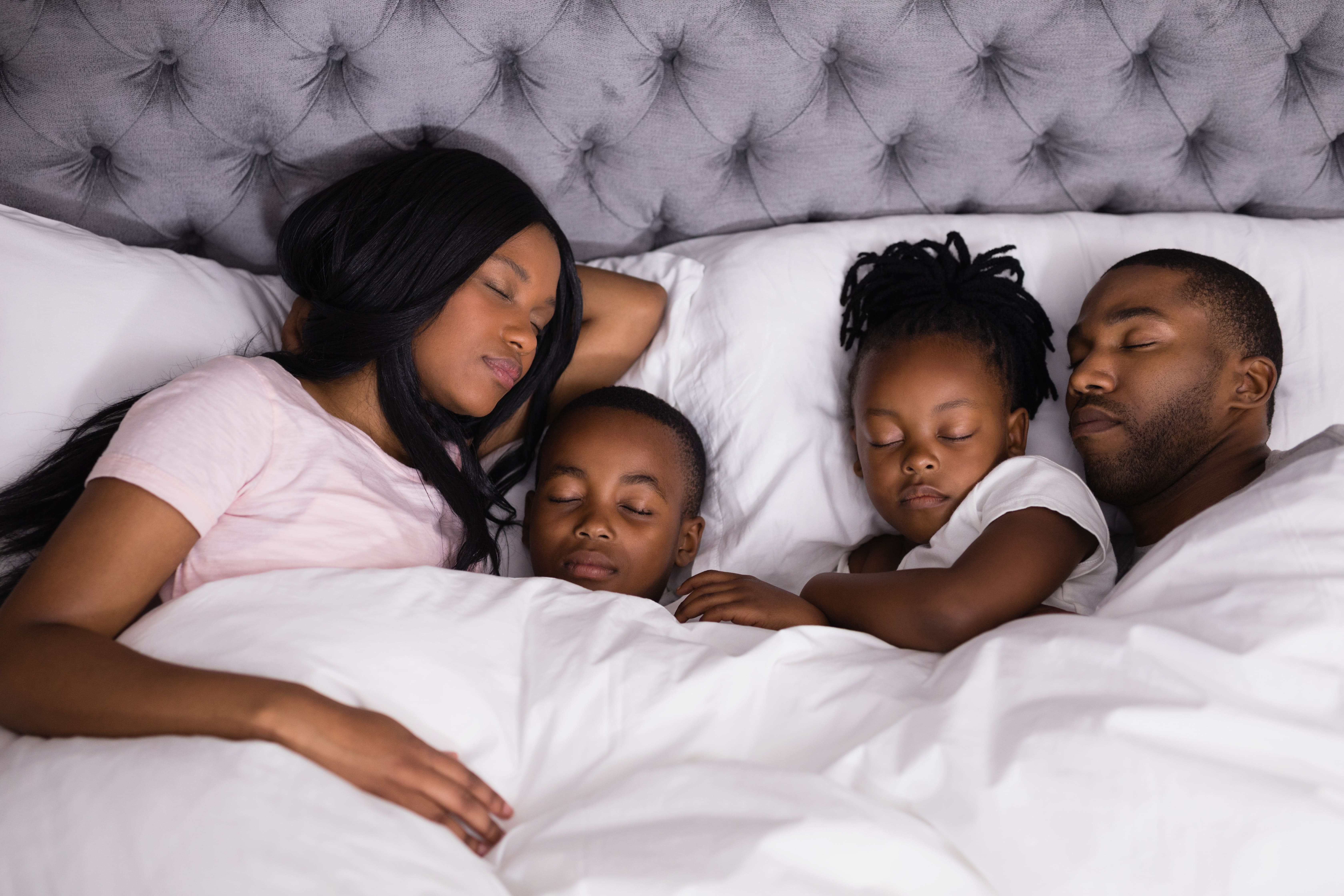 Vista de alto ângulo da família negra dormindo juntos na cama