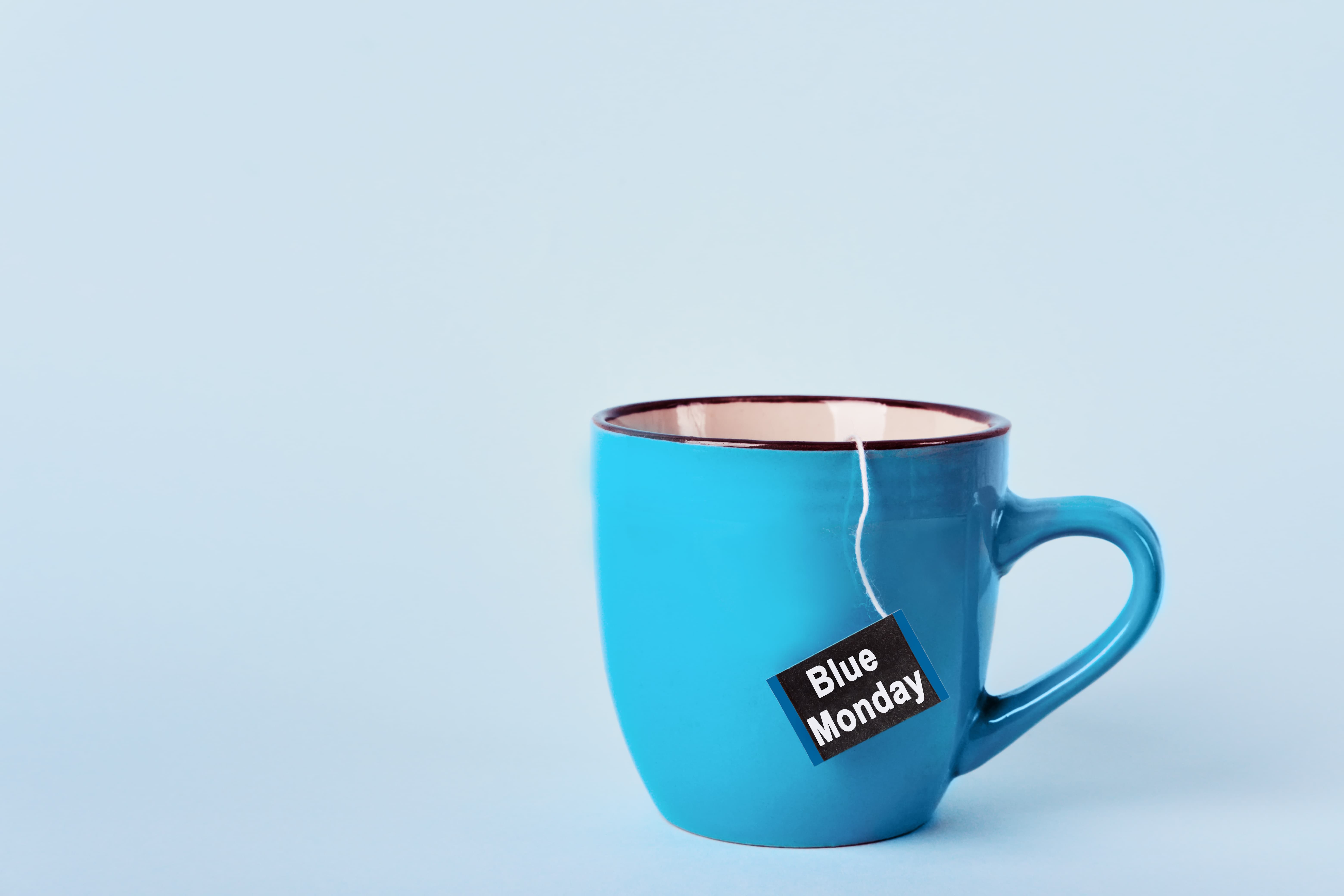 xícara azul com etiqueta de chá escrito "blue monday"