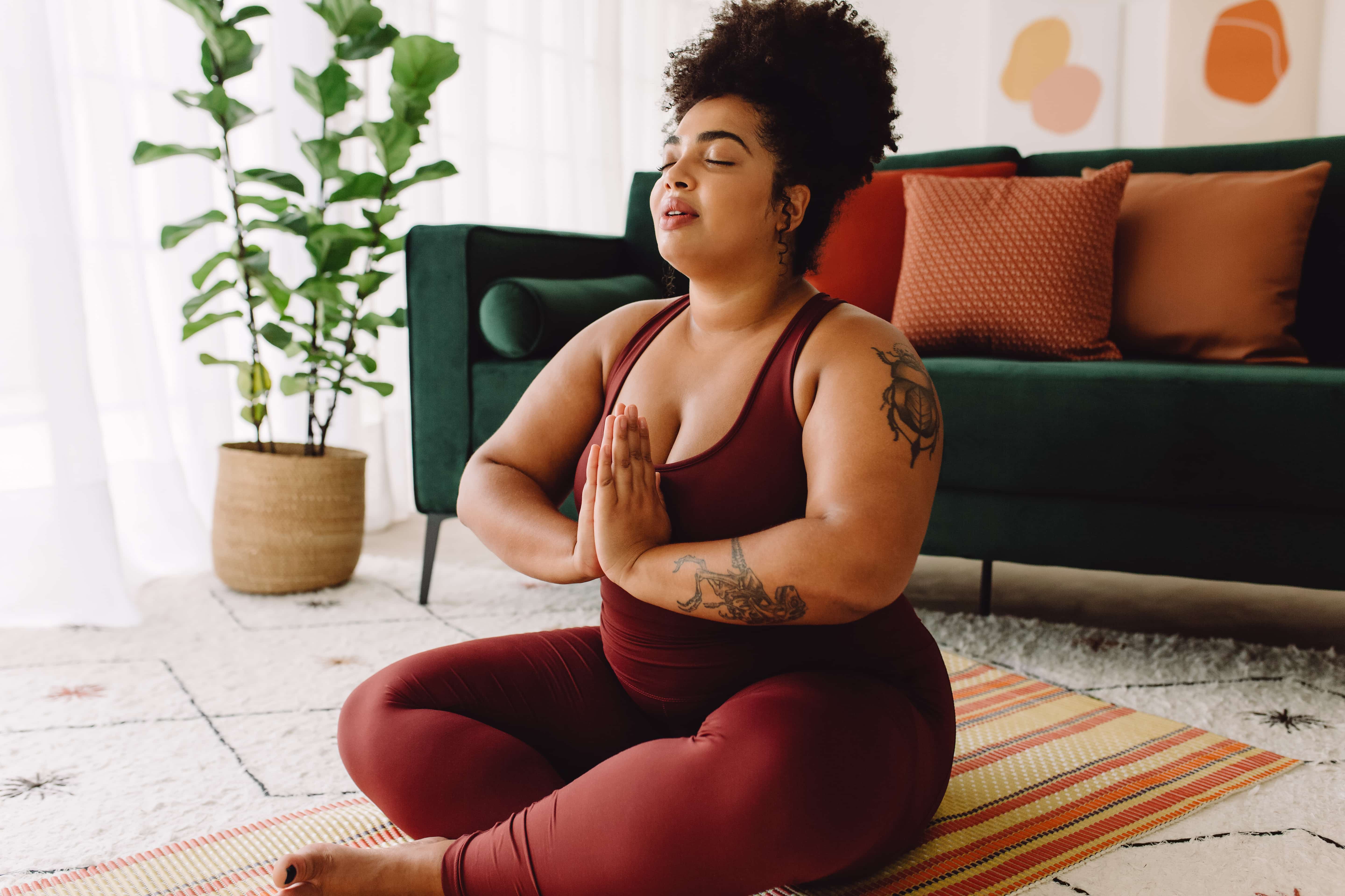 mulher negra saudável praticando yoga em casa
