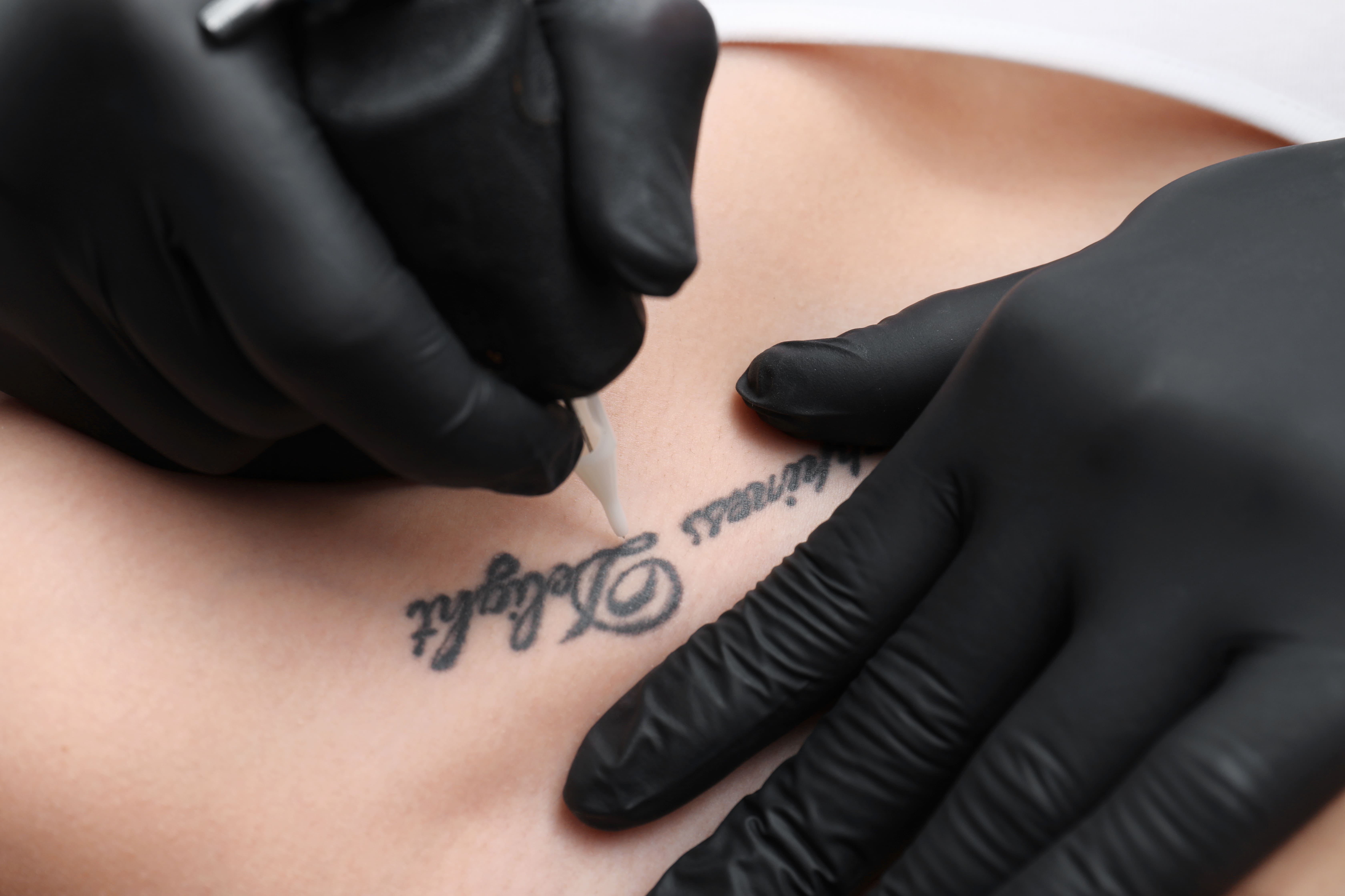 Close-up em mãos fazendo uma tatuagem