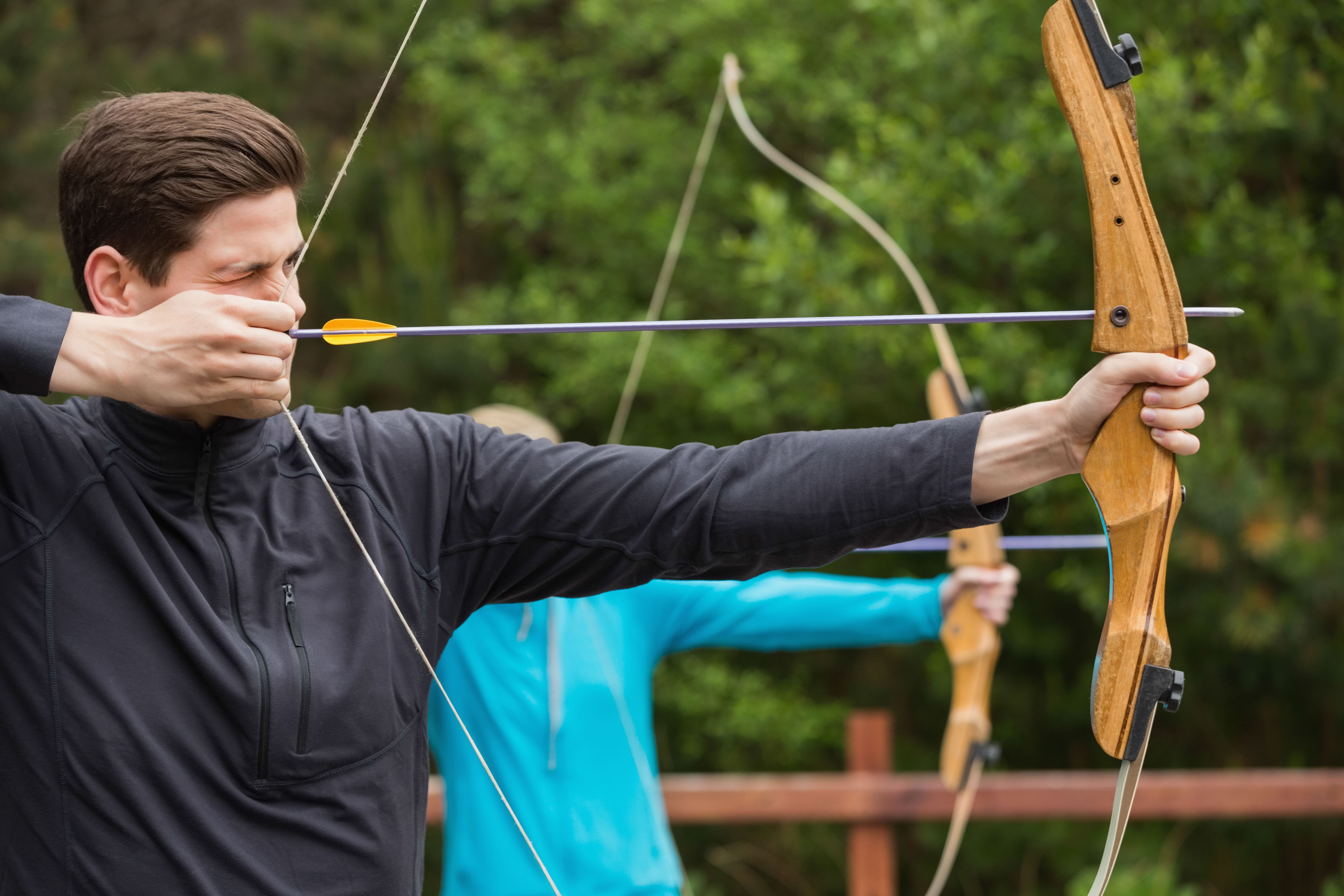 Homem praticando arco e flecha